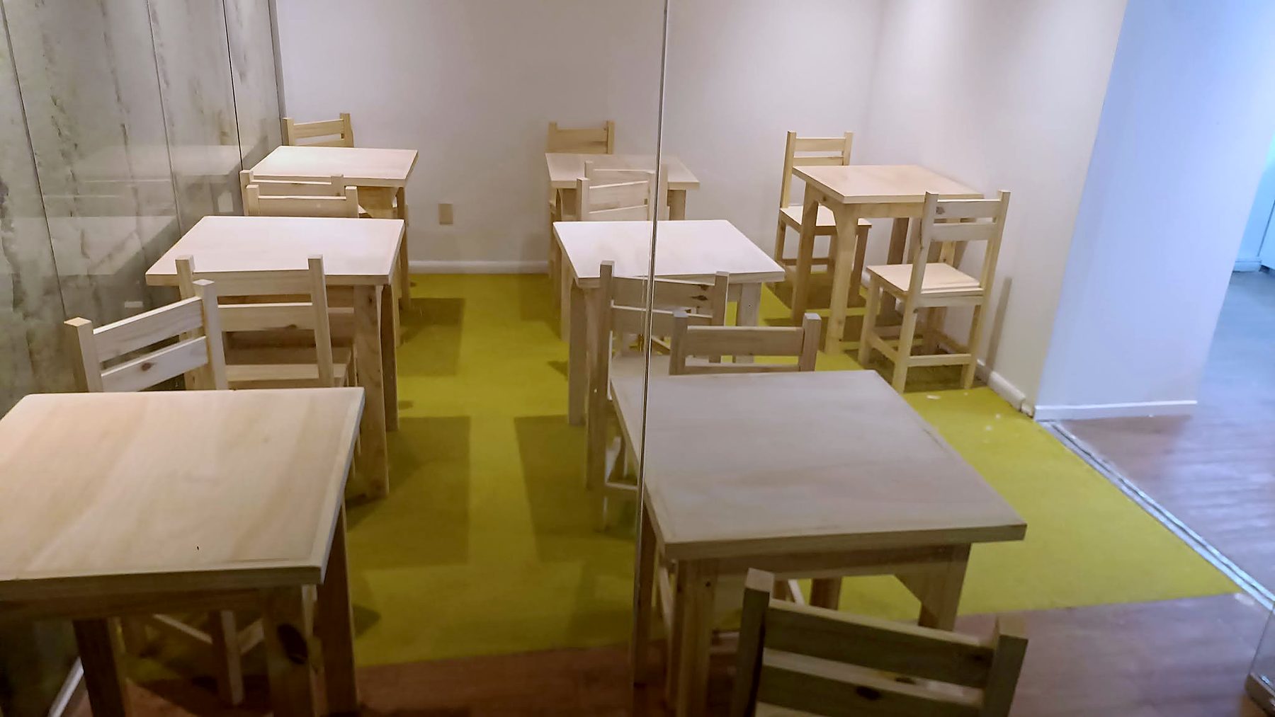 Sala común con mesas y sillas de madera