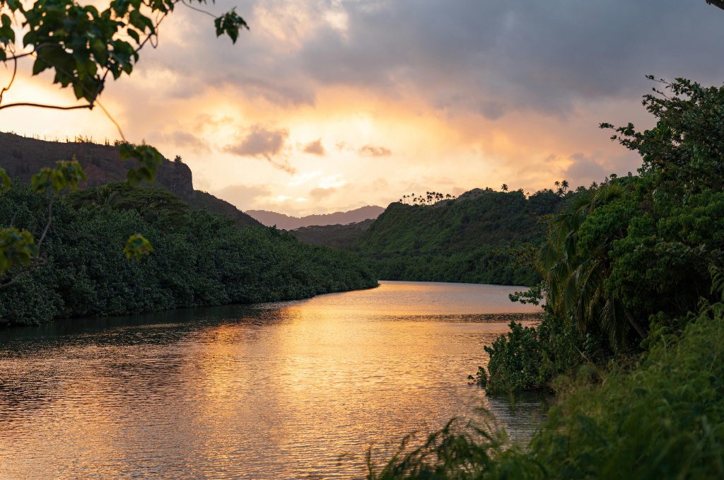 A serene Hawaiian river valley at sunset