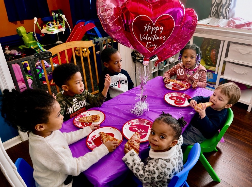 Valentine's Day Pizza Party Children celebrating Valentine's Day with heart balloons and pizza at a festive party table at Insight Kidz Care Baltimore child care