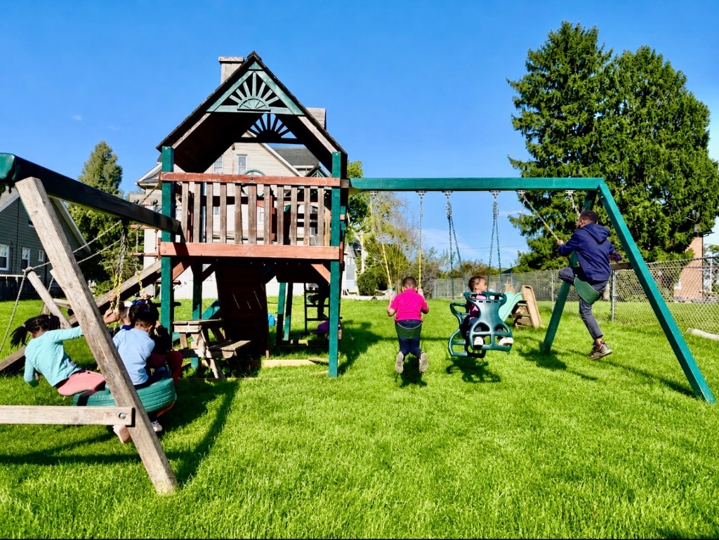 Sunny Day Swings Children swinging on swings on a bright sunny day in the large grassy yard at Insight Kidz Care licensed child care Baltimore
