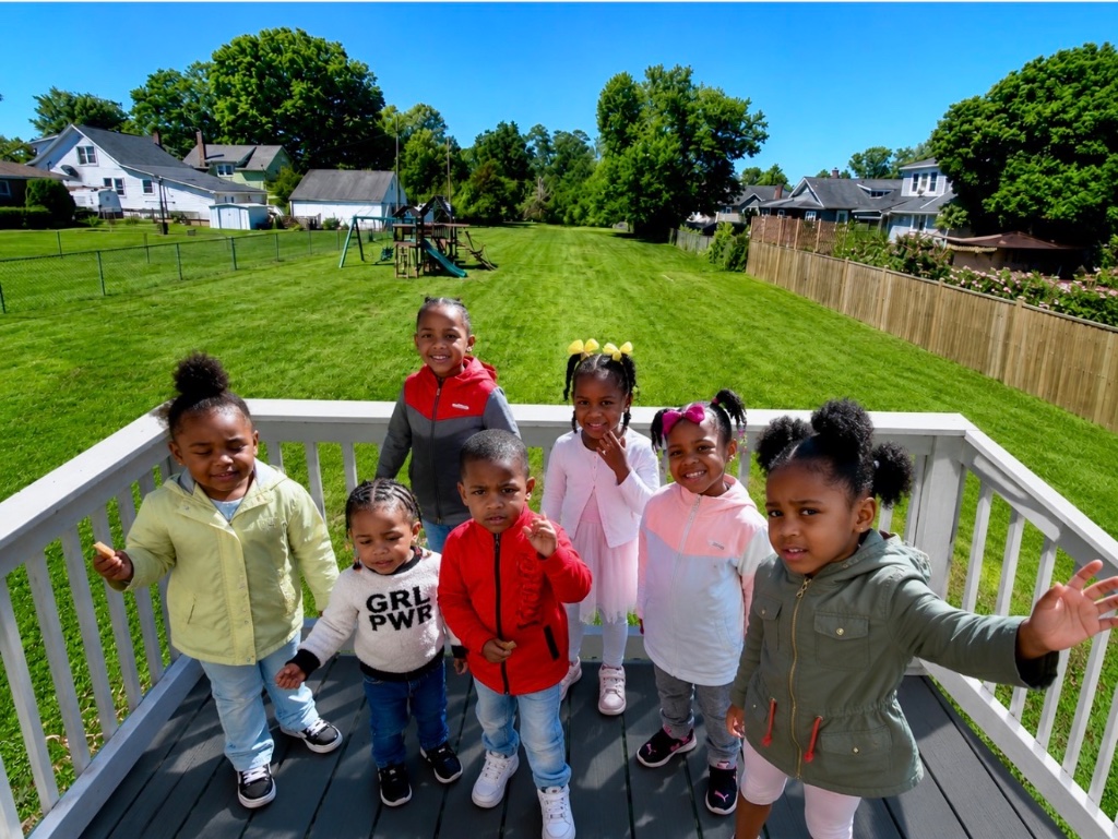 Outdoor Group Selfie Teacher and children taking a sunny outdoor group selfie at Insight Kidz Care licensed Baltimore family child care
