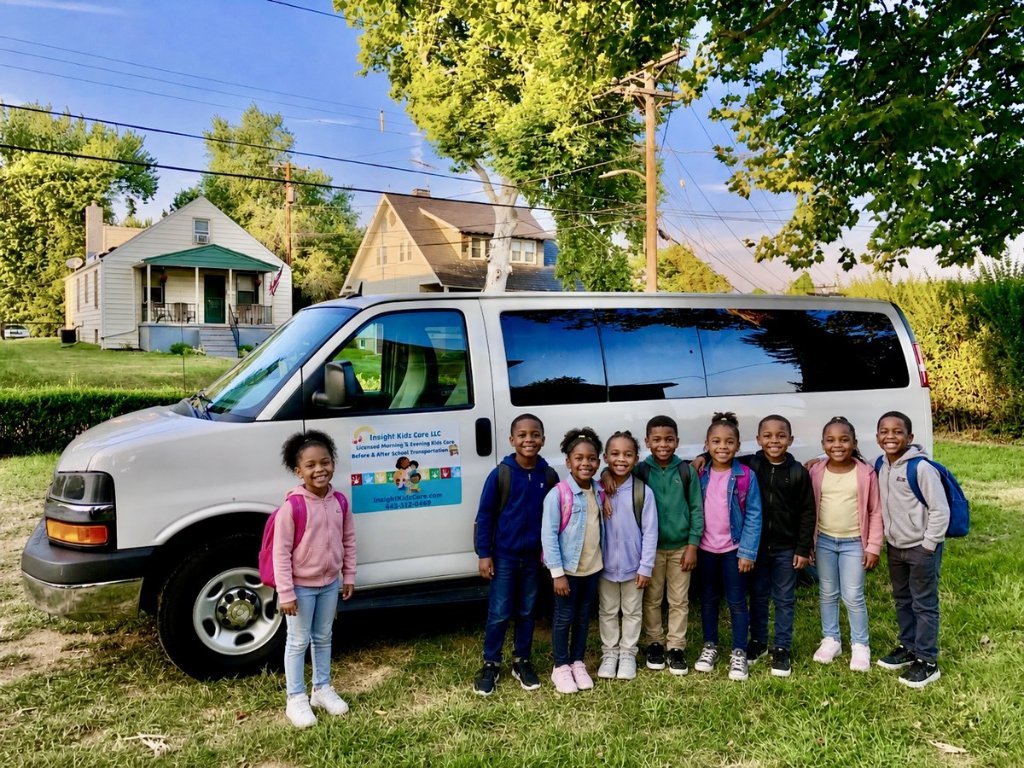 Before & After School Transportation Van Children with backpacks standing in front of the branded Insight Kidz Care LLC transportation van used for before and after school care in Baltimore