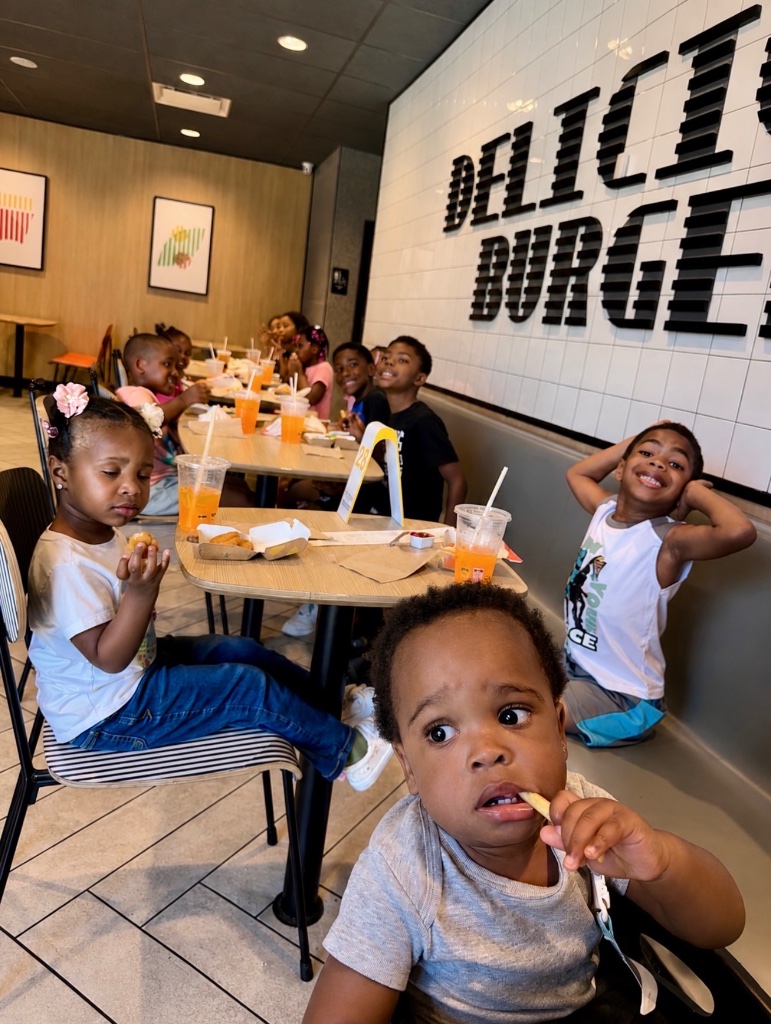 Restaurant Outing with Friends Children and staff enjoying a meal at a burger restaurant during an Insight Kidz Care summer program outing in Baltimore