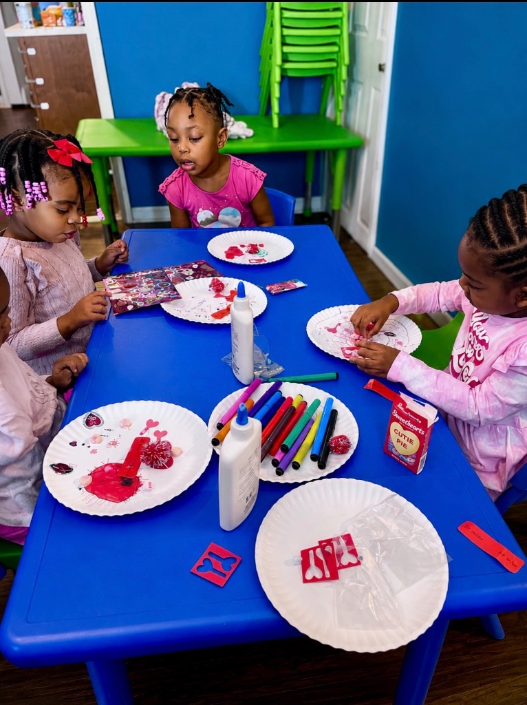 Valentine's Day Craft Time Children making Valentine's Day crafts with stickers, markers, and glue on paper plates at Insight Kidz Care Baltimore family child care