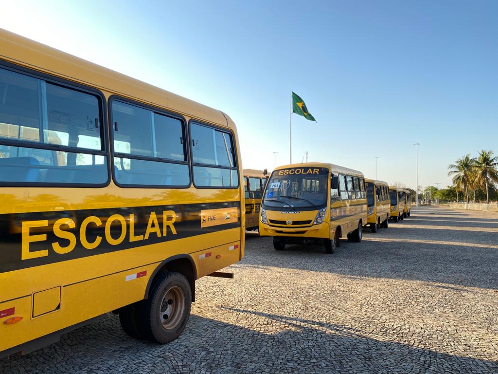 Ônibus escolares amarelos estacionados em paralelepípedos
