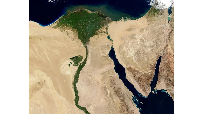 A satellite view of Egypt showing the green ribbon of the Nile cutting through the desert.