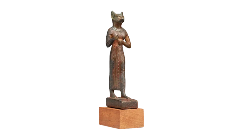 A bronze statuette of the cat-goddess Bastet standing upright in a long robe.