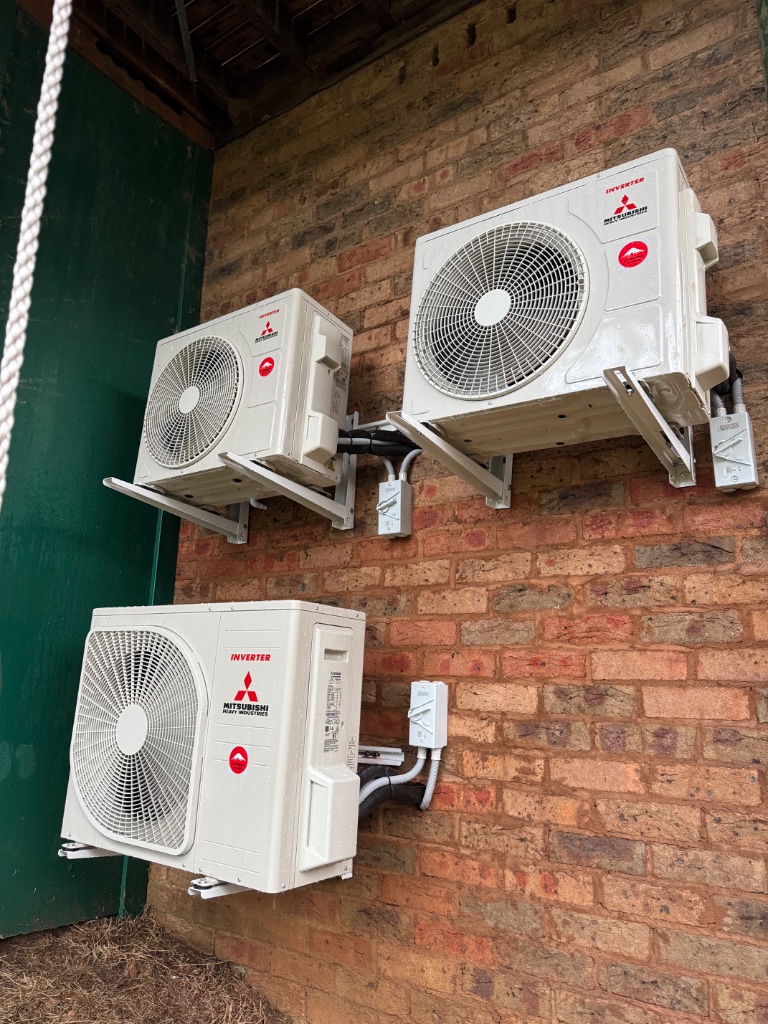 Three Mitsubishi Heavy Industries outdoor condensers wall-mounted on brick in Katoomba — BAL Flame Zone compliant