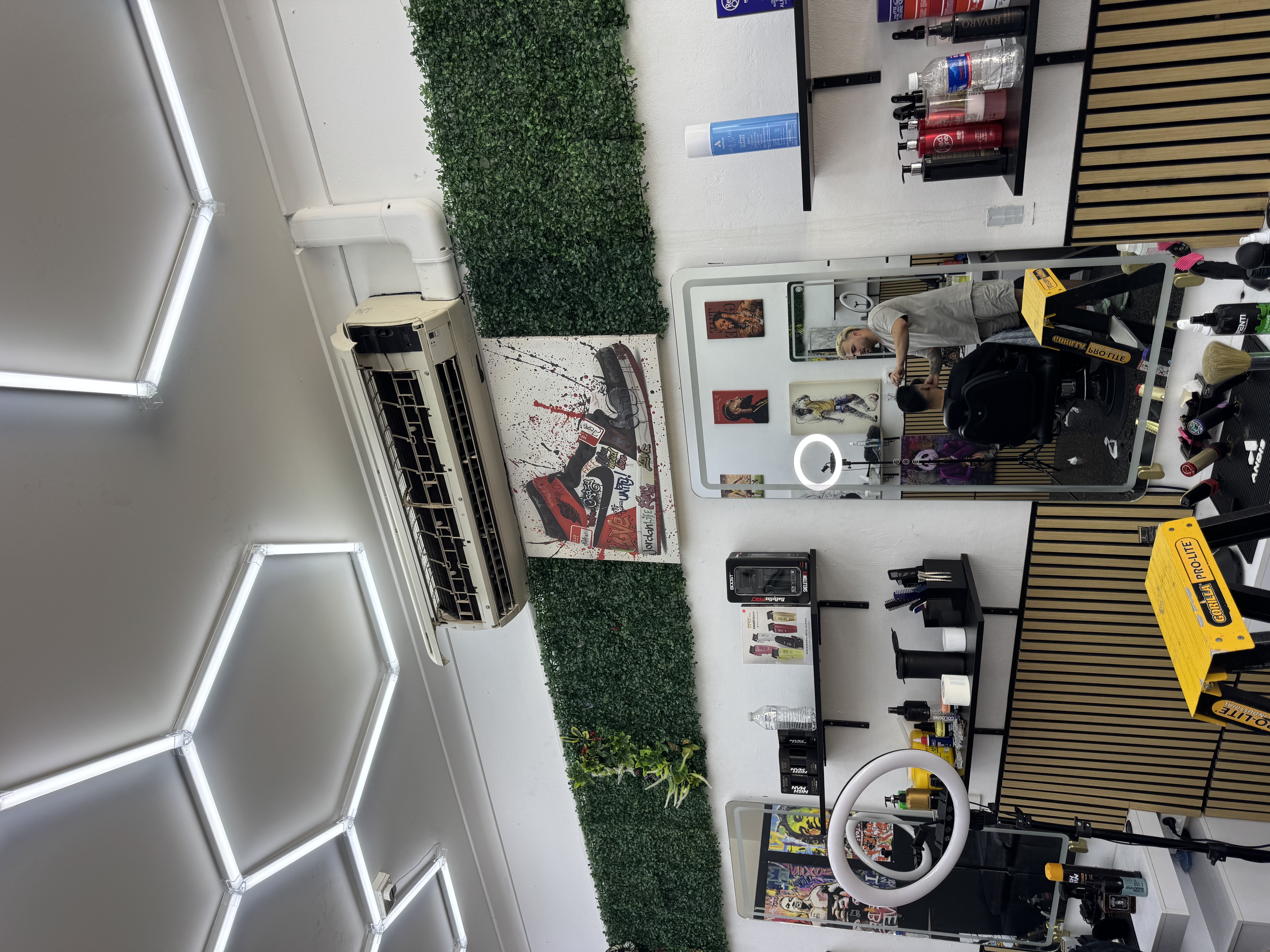 Wall-mounted split-system air conditioner with its front cover open during commercial work at The OG Barbershop in Emu Plains