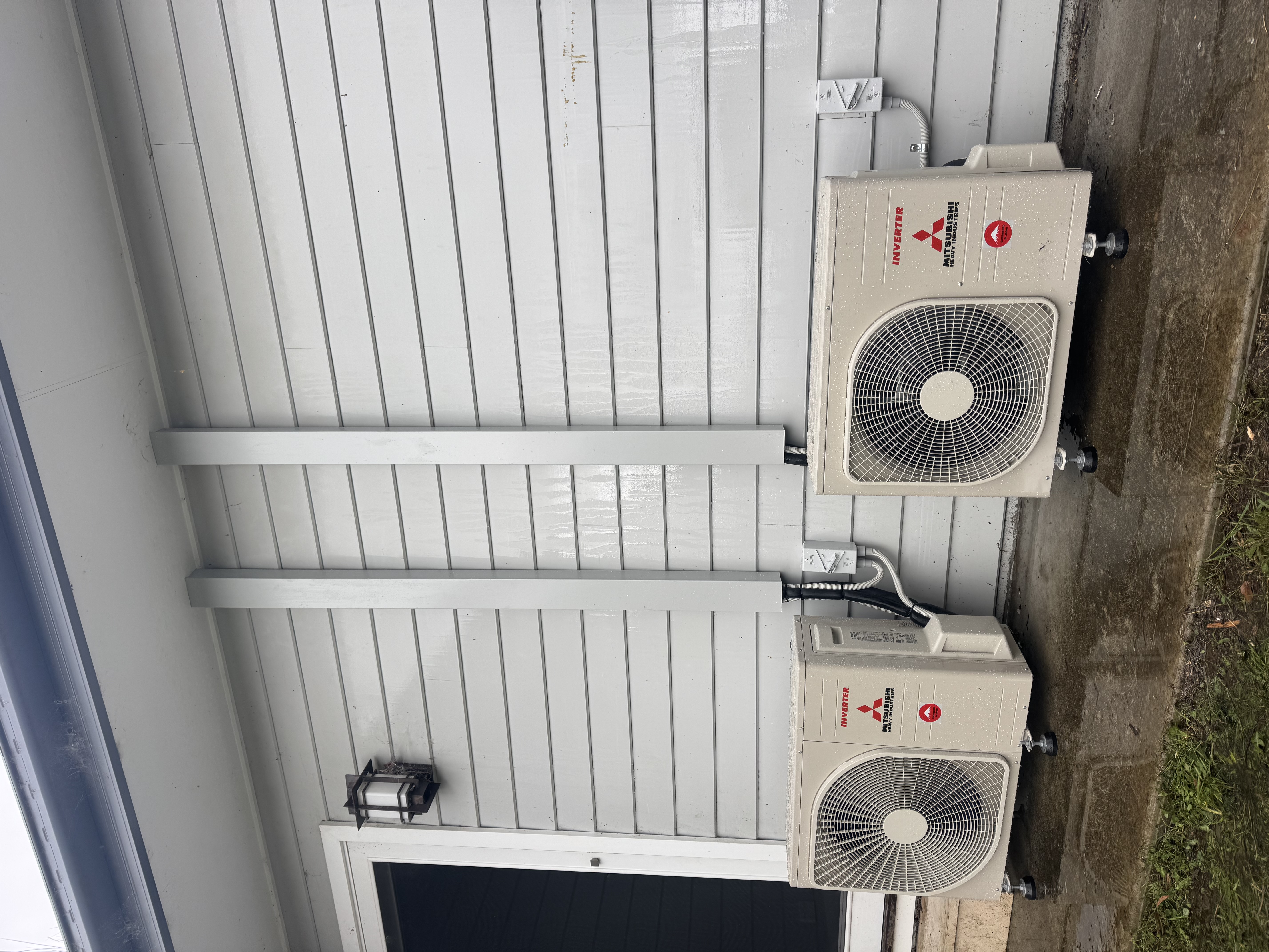 Two Mitsubishi Heavy Industries outdoor air conditioning units with covered pipework at a Hartley / Little Hartley property