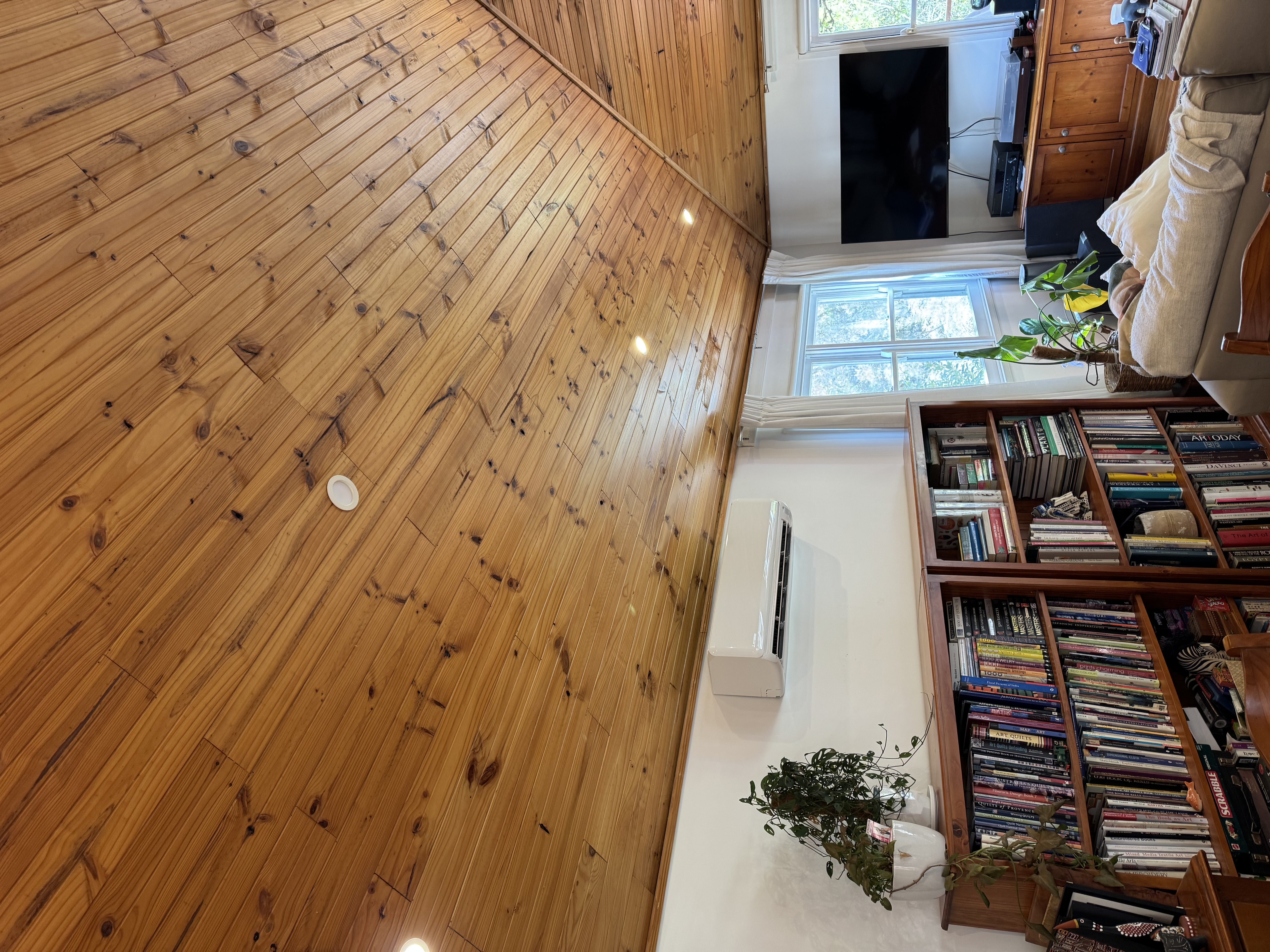 Wall-mounted split system in a living area with timber ceiling