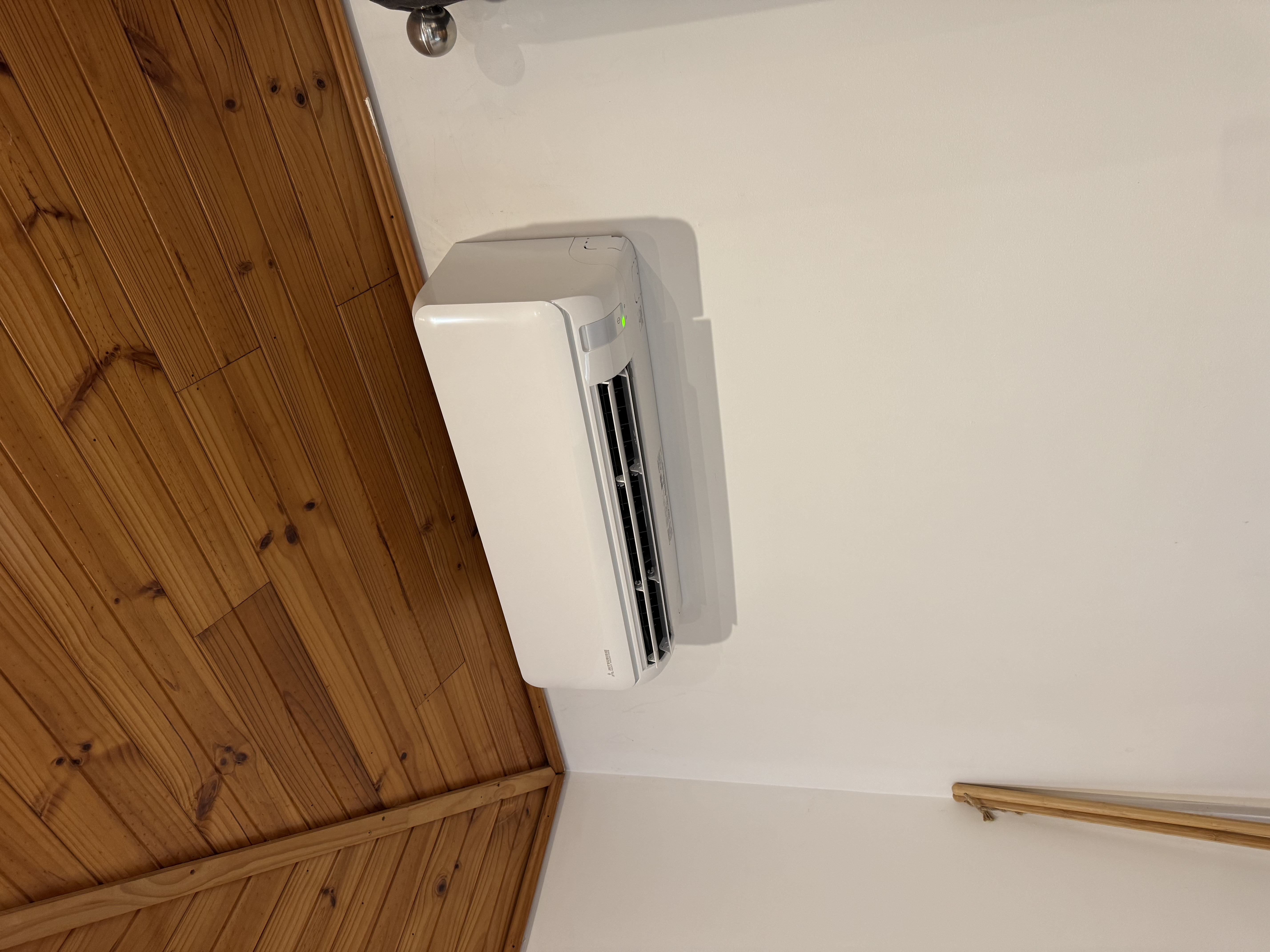 Close view of a wall-mounted split system beneath a timber ceiling