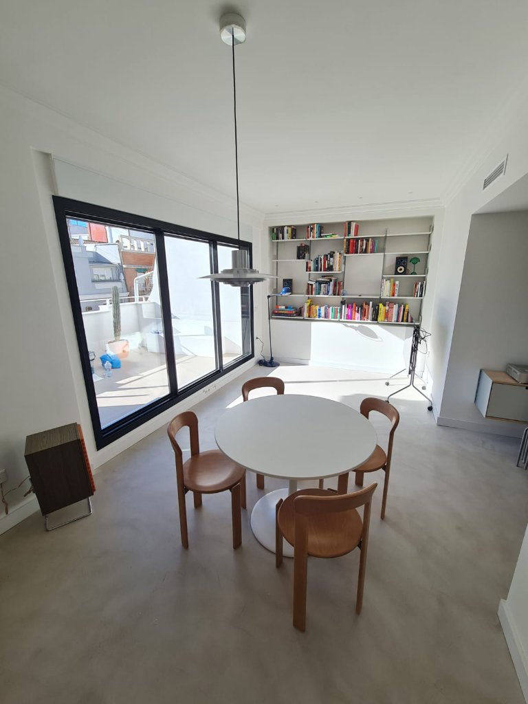 Salón comedor con gran ventanal aluminio negro