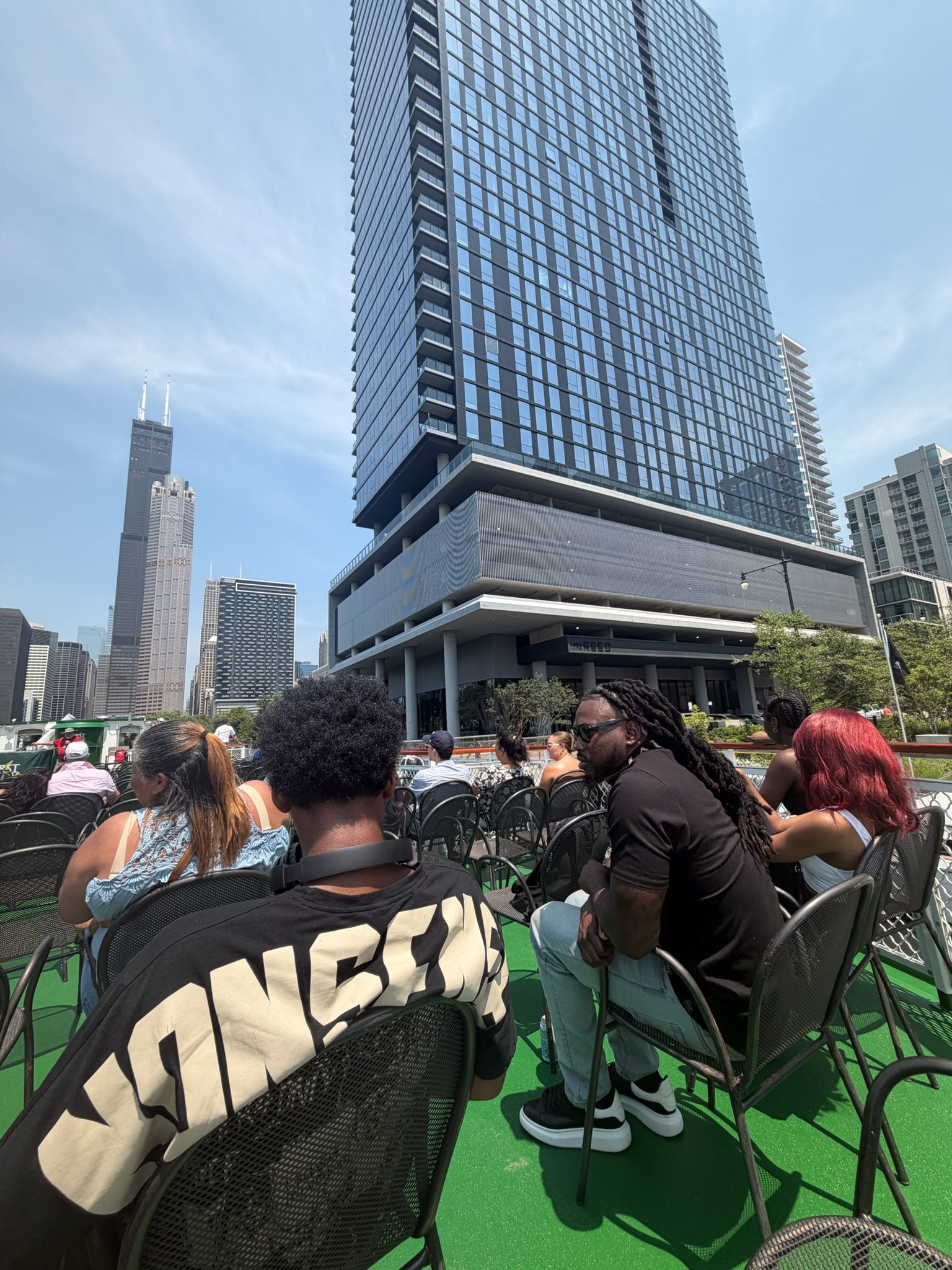 Students seated on the boat deck looking out at the Chicago skyline including Willis Tower