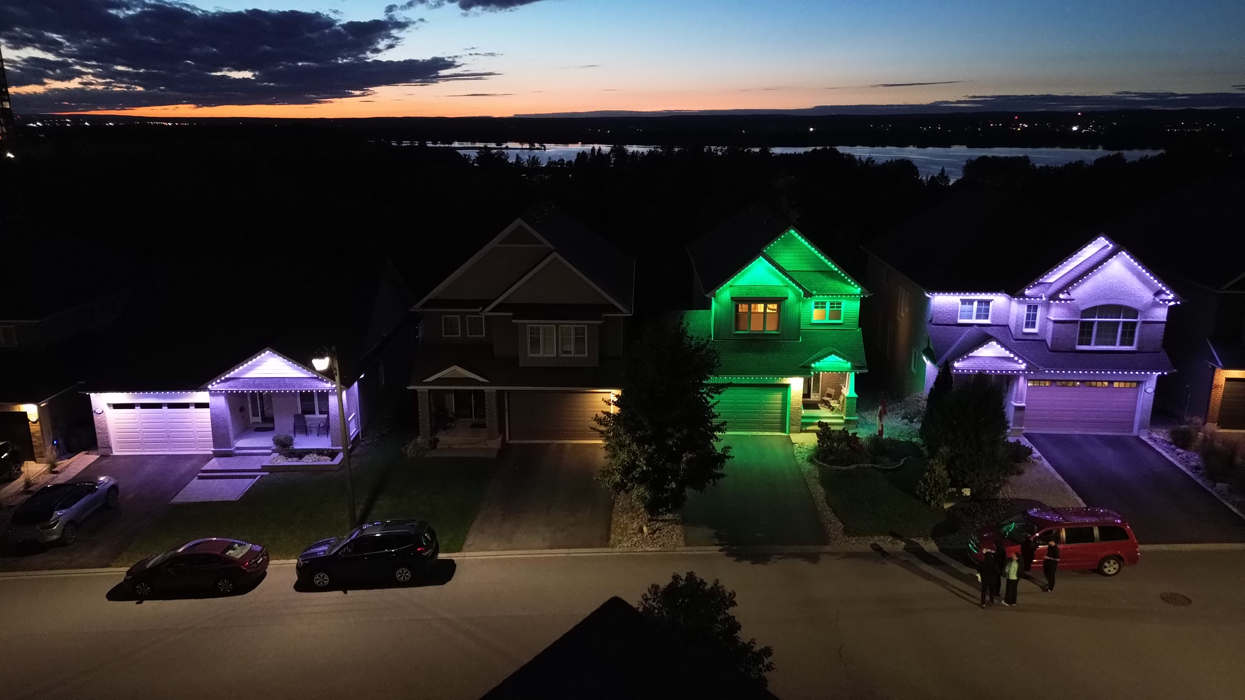 White, green and purple lighting across several homes