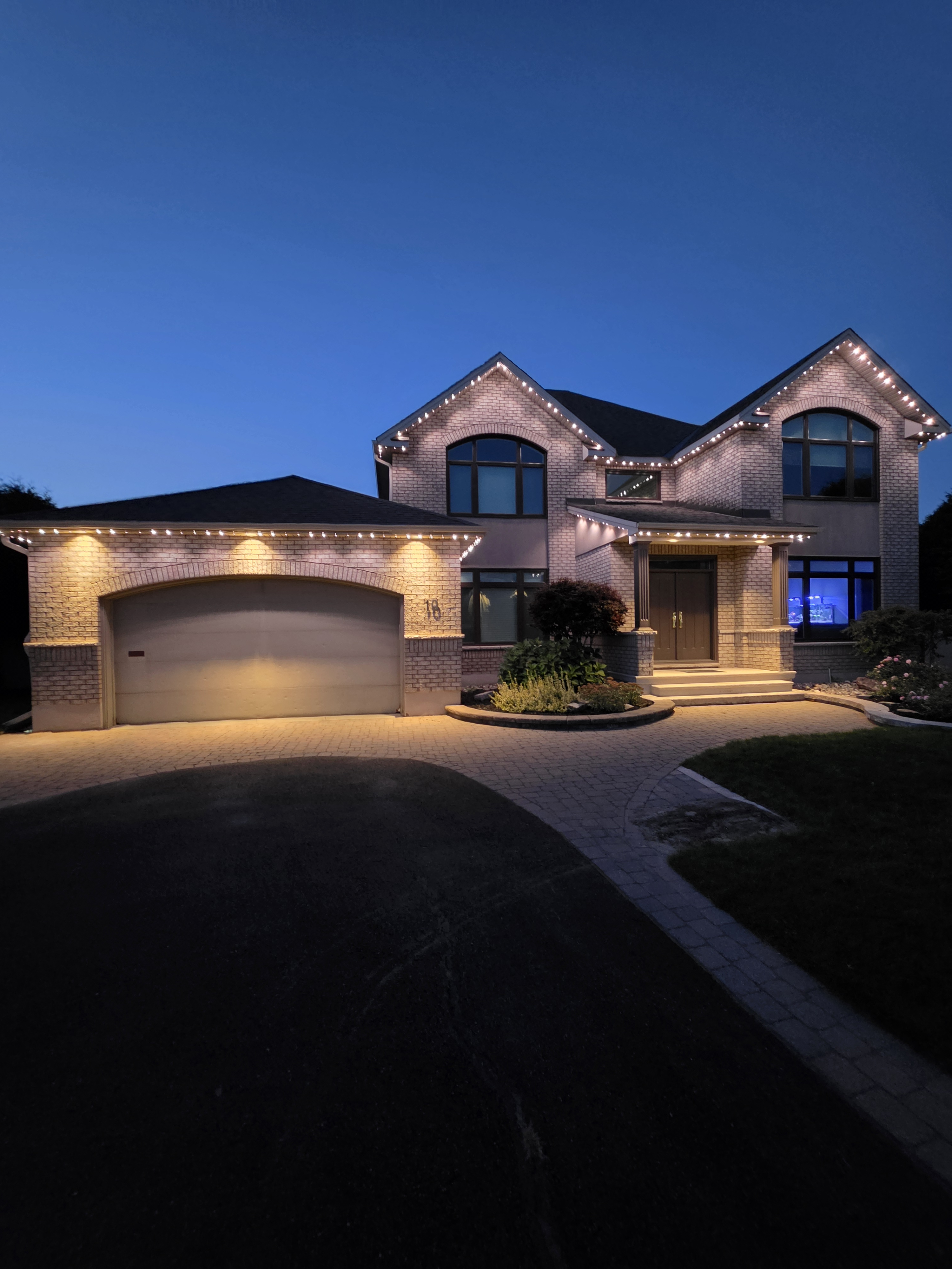Residential home with permanent roofline lighting at twilight