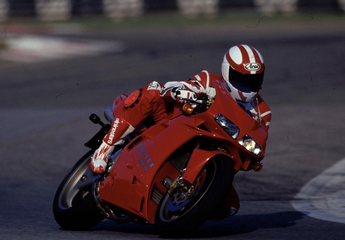 Red Ducati 916 leaning hard into a corner