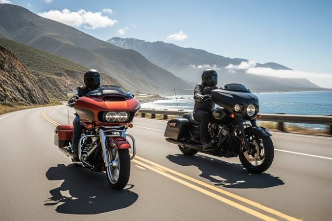 Two motorcyclists riding side by side on a coastal highway