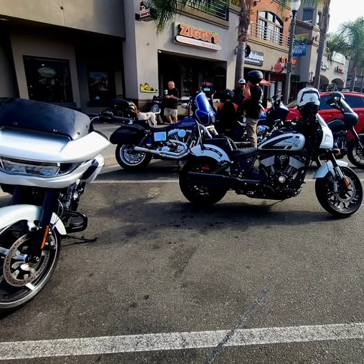 White Harley-Davidson and Indian Chief parked side by side outside a building