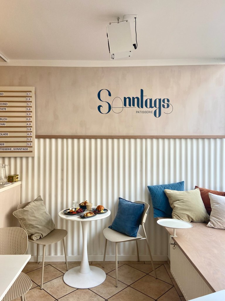 Minimalistisches Interieur des Sonntags Cafés mit klaren Linien und Preußisch-Blau-Akzenten