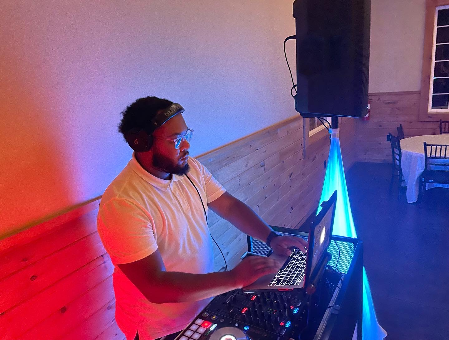 DJ mixing under red and cyan stage lighting