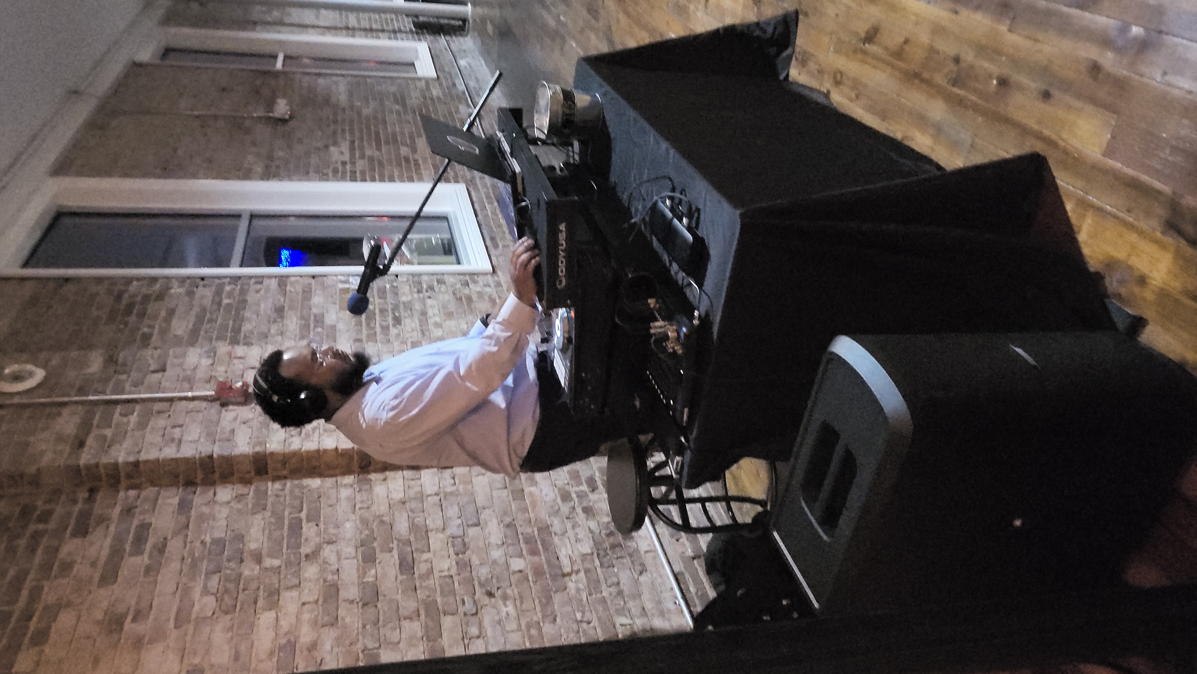 DJ working the booth in a brick-walled venue