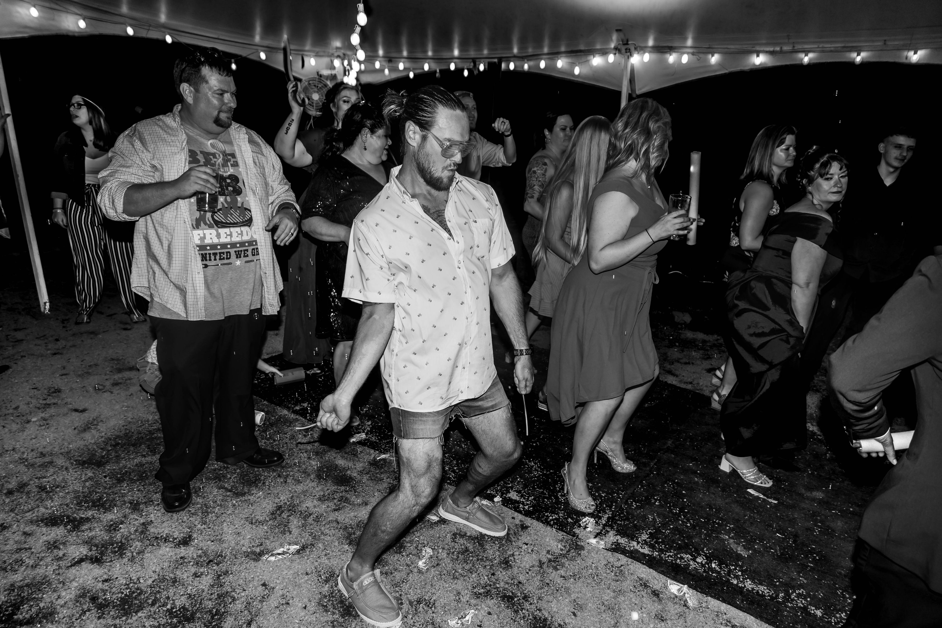 Guests dancing under string lights at a private event