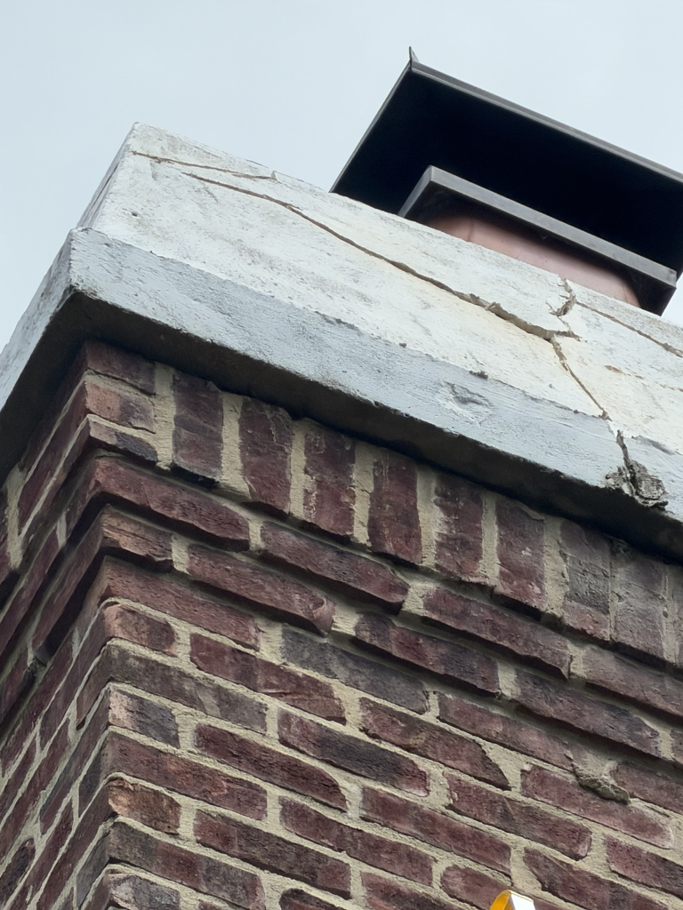 Spalled concrete repair in progress — chimney crown