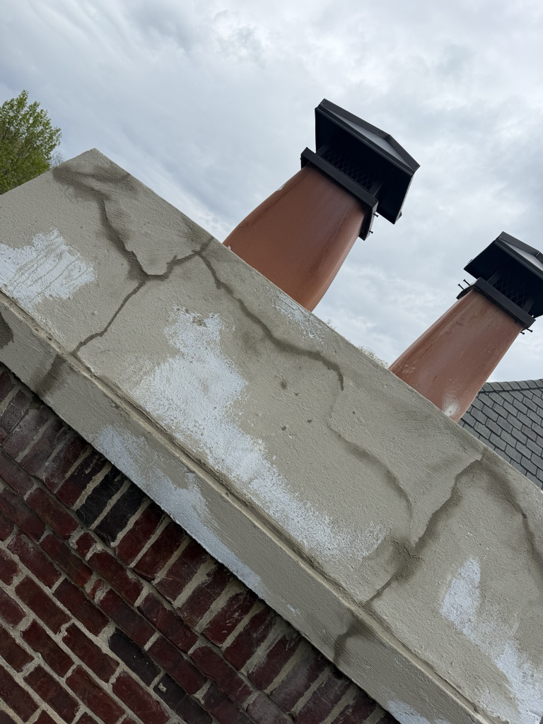 Fresh concrete patch applied to chimney crown
