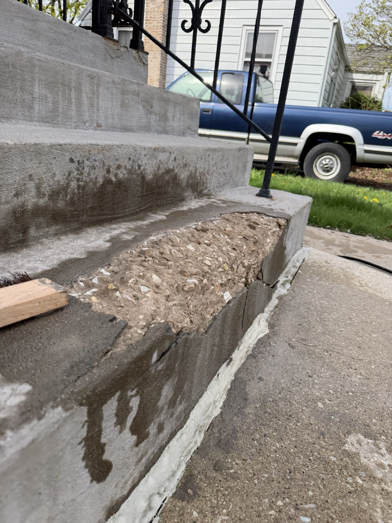 Damaged concrete step edge before patching
