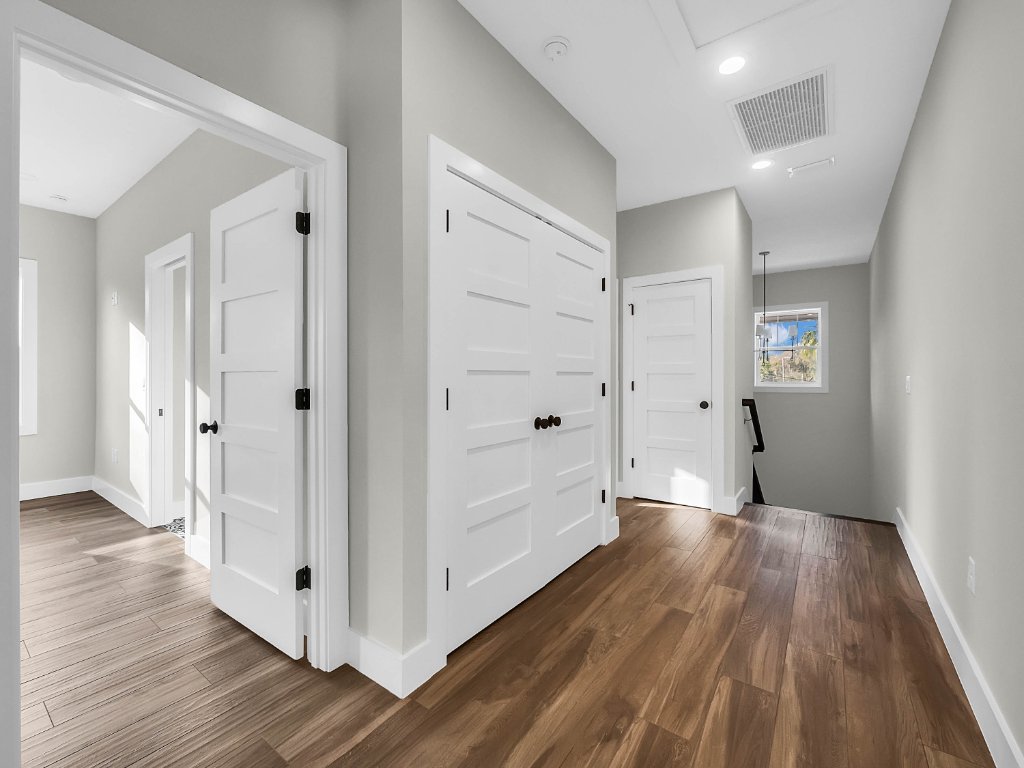Modern farmhouse new construction with white board-and-batten exterior, metal roof, and front porch in Orlando