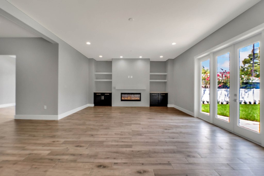 Contemporary spec home at 1332 W Yale Street, College Park, Orlando FL — gray stucco exterior with standing-seam metal roof, red double doors, glass garage, and tropical landscaping.