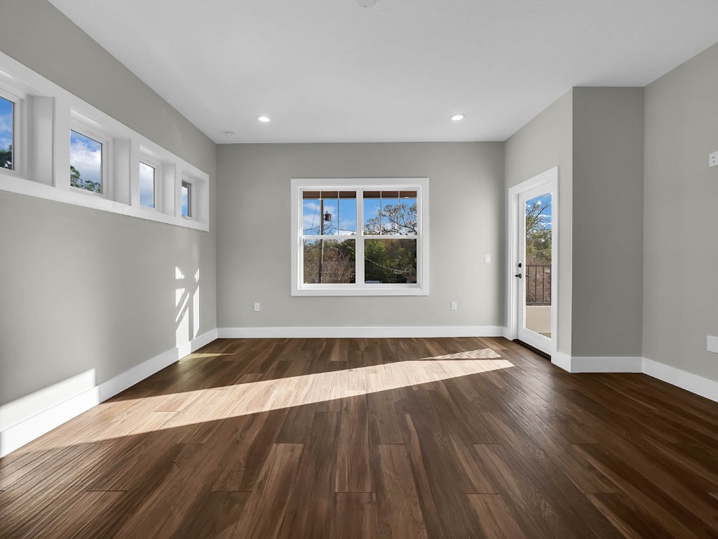 Modern farmhouse new construction with white board-and-batten exterior, metal roof, and front porch in Orlando