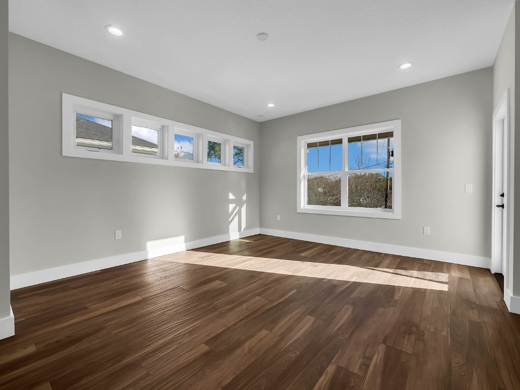 Modern farmhouse new construction with white board-and-batten exterior, metal roof, and front porch in Orlando