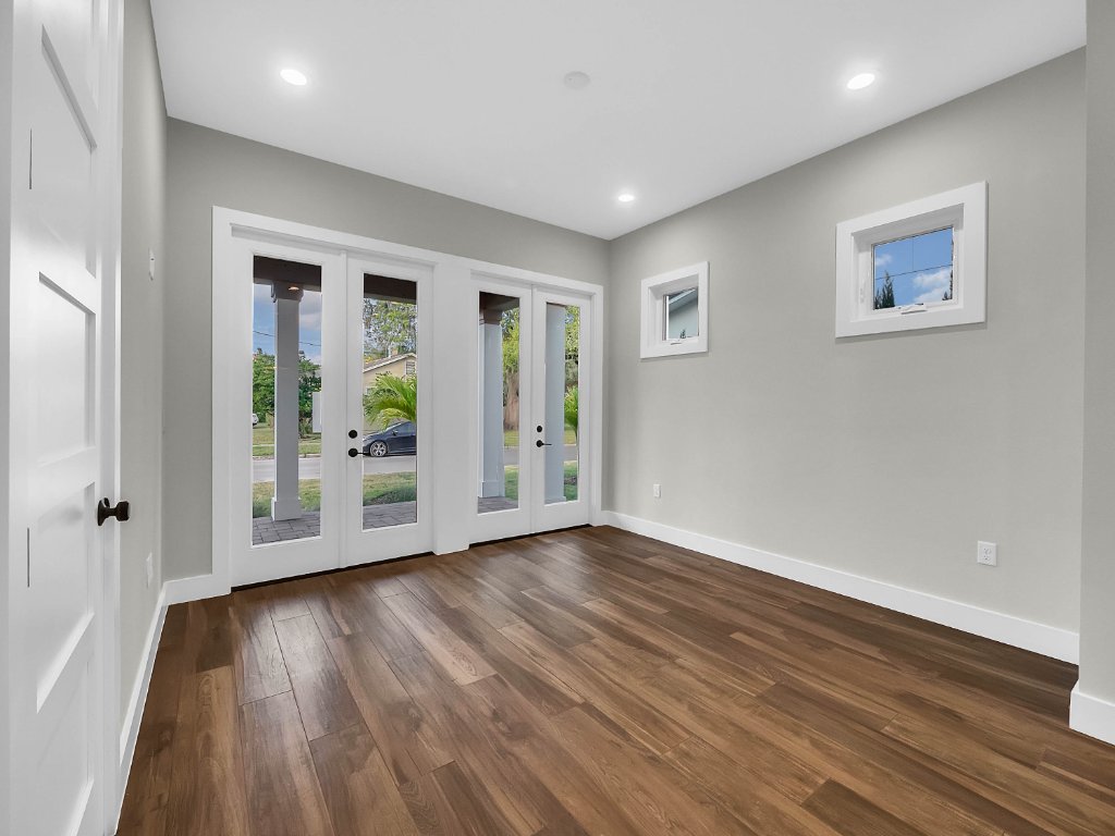 Modern farmhouse new construction with white board-and-batten exterior, metal roof, and front porch in Orlando