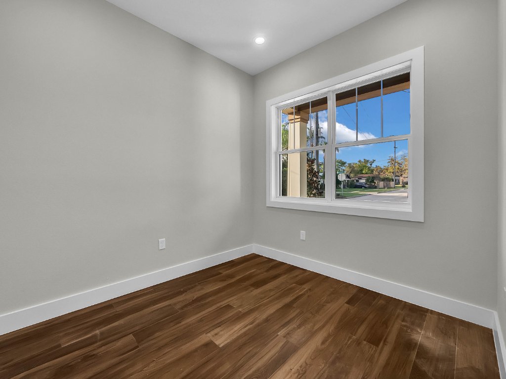Modern farmhouse new construction with white board-and-batten exterior, metal roof, and front porch in Orlando