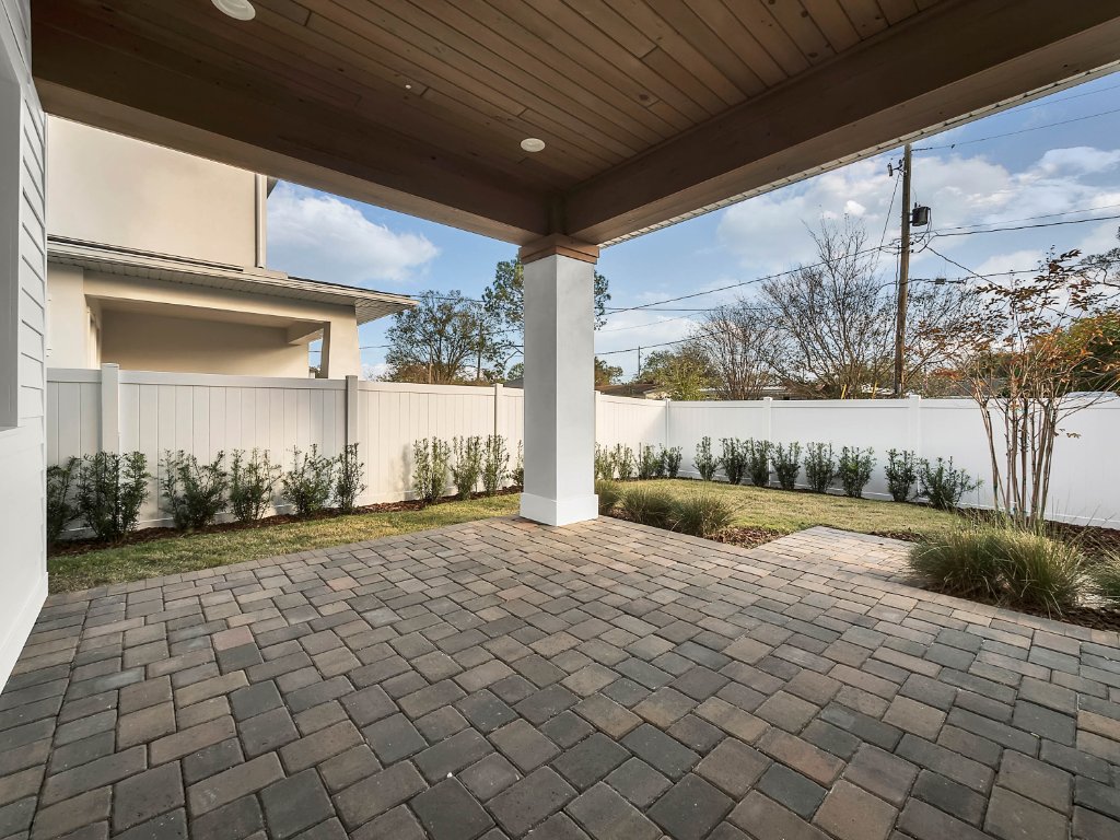 Modern farmhouse new construction with white board-and-batten exterior, metal roof, and front porch in Orlando