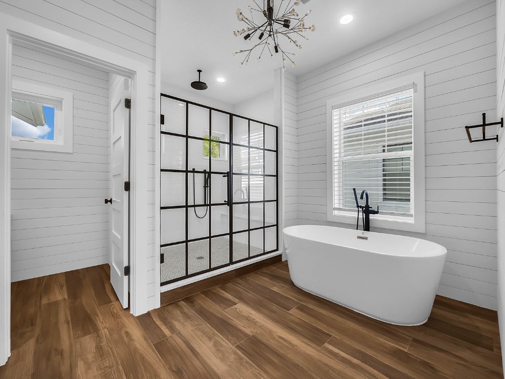 Modern farmhouse new construction with white board-and-batten exterior, metal roof, and front porch in Orlando