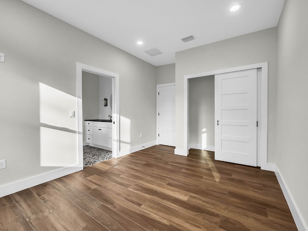 Modern farmhouse new construction with white board-and-batten exterior, metal roof, and front porch in Orlando