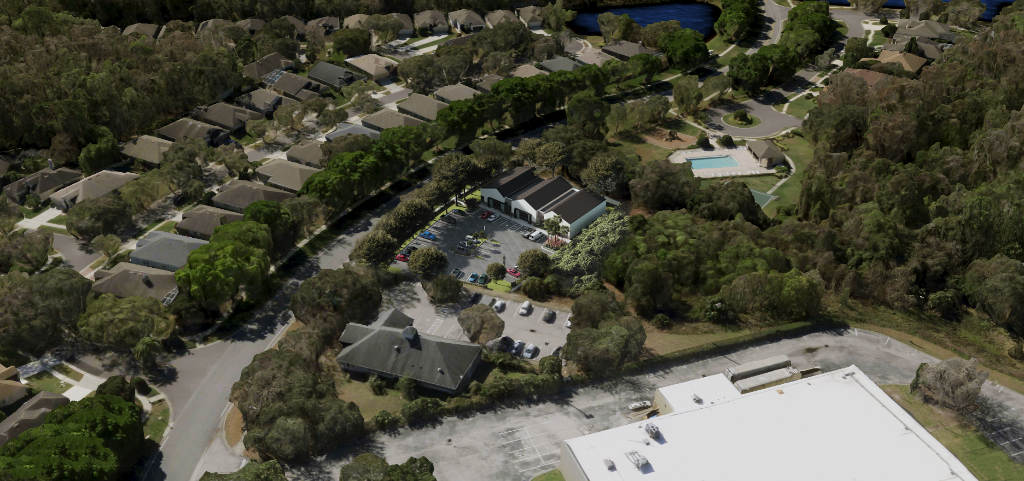 Vista Willa Medical Office in Winter Springs, FL — three white gabled bays with standing-seam metal roofs and natural stone bases, fronted by accessible parking and ornamental landscaping at sunset