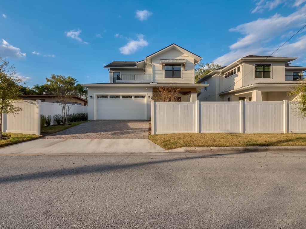 Modern farmhouse new construction with white board-and-batten exterior, metal roof, and front porch in Orlando