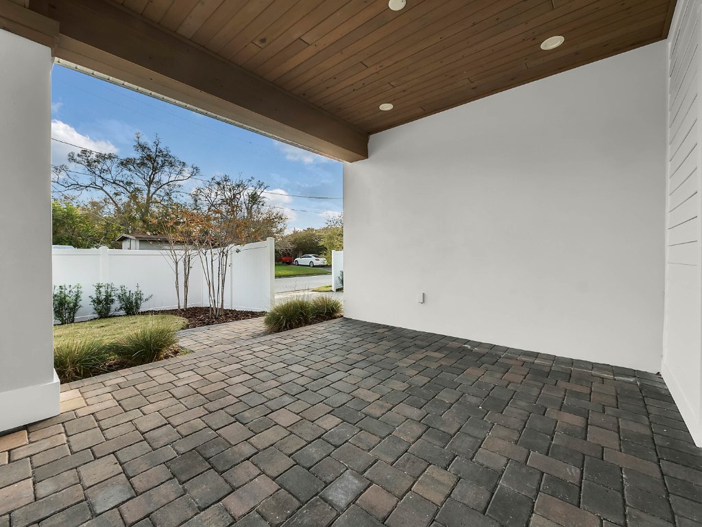 Modern farmhouse new construction with white board-and-batten exterior, metal roof, and front porch in Orlando