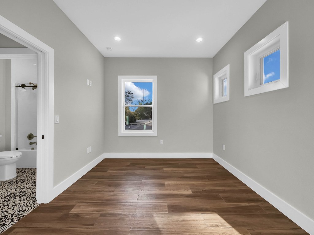 Modern farmhouse new construction with white board-and-batten exterior, metal roof, and front porch in Orlando