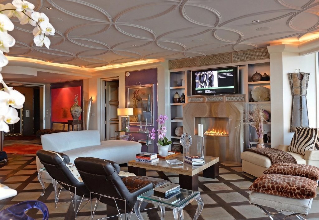 Luxury condo interior with ornate ceiling medallions, fireplace, and eclectic furnishings in New Smyrna Beach