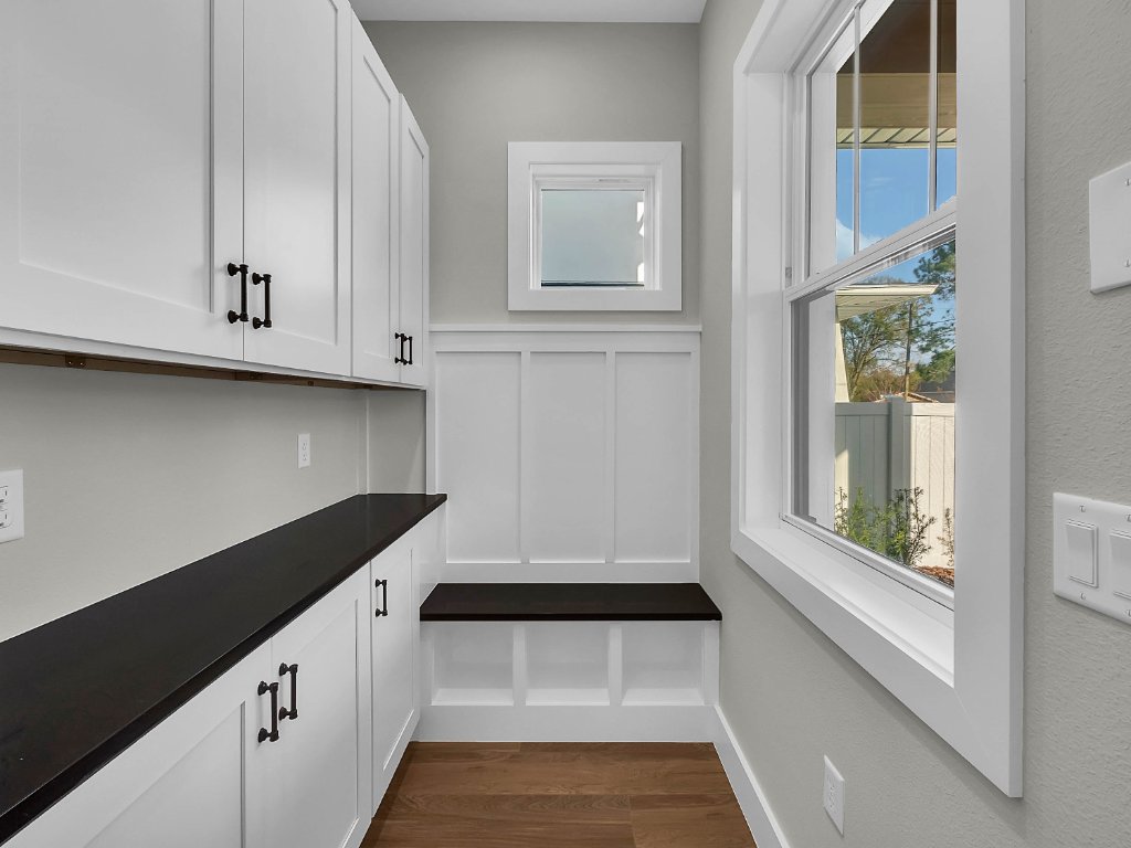 Modern farmhouse new construction with white board-and-batten exterior, metal roof, and front porch in Orlando