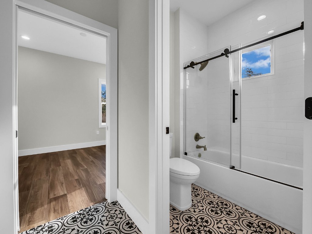 Modern farmhouse new construction with white board-and-batten exterior, metal roof, and front porch in Orlando