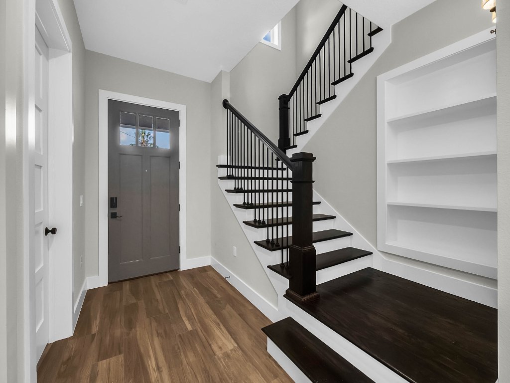Modern farmhouse new construction with white board-and-batten exterior, metal roof, and front porch in Orlando