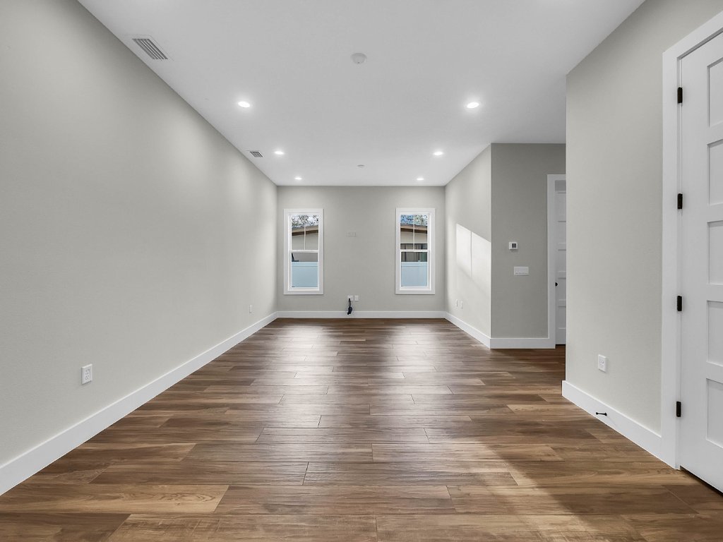 Modern farmhouse new construction with white board-and-batten exterior, metal roof, and front porch in Orlando