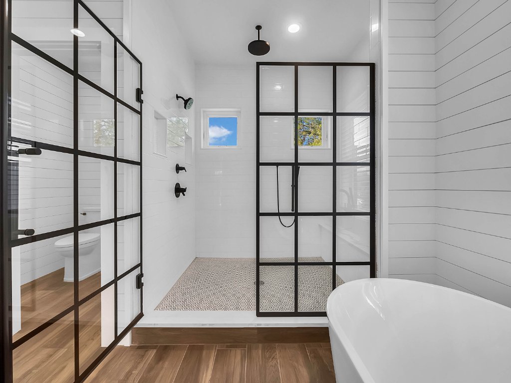 Modern farmhouse new construction with white board-and-batten exterior, metal roof, and front porch in Orlando