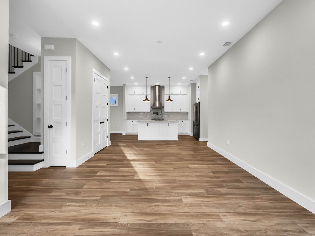 Modern farmhouse new construction with white board-and-batten exterior, metal roof, and front porch in Orlando